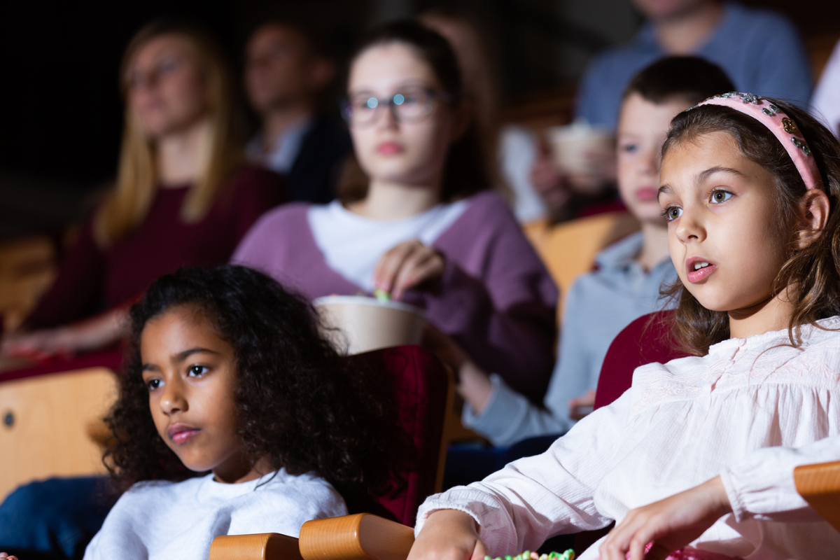 Children sat in a dark auditorium watching a show